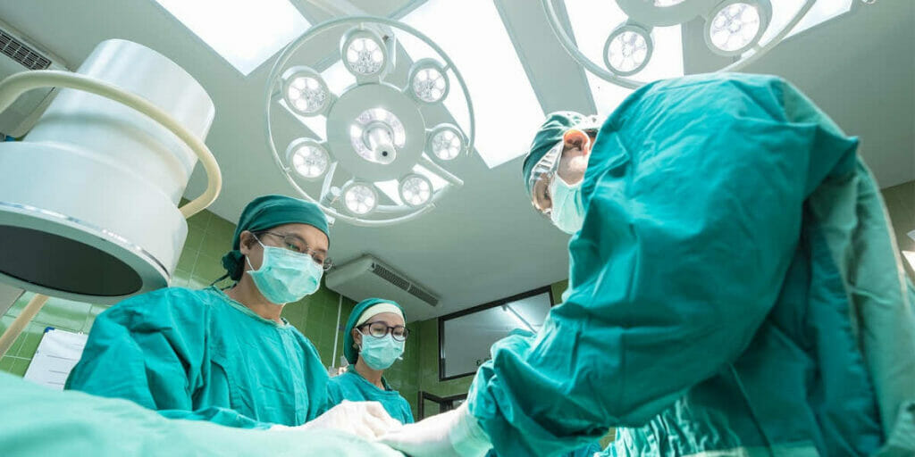 A group of surgeons in an operating room, following best practices to prevent healthcare-associated infections.